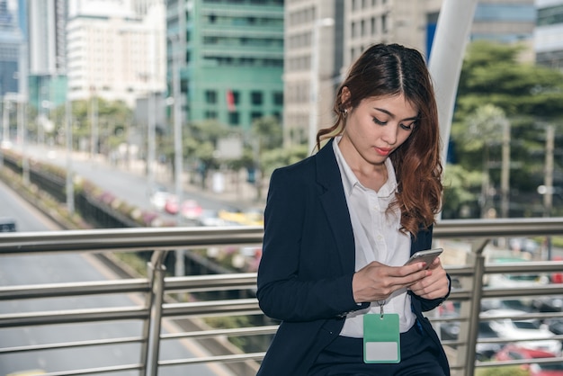 Portraits of beautiful asian woman look confidence is holding cellphone