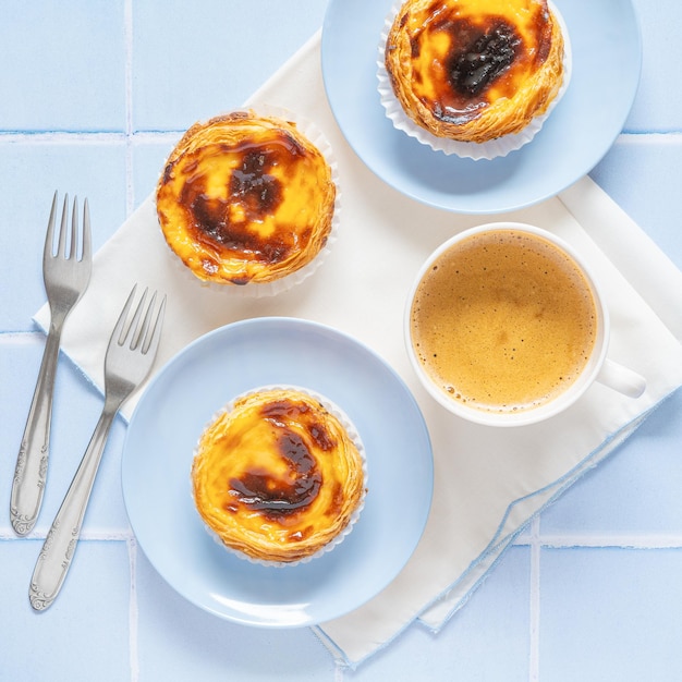 Portuguese dessert Pastel de nata with coffee on blue tile