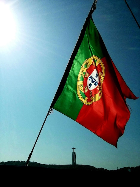 Photo portuguese flag on silhouette field against clear sky