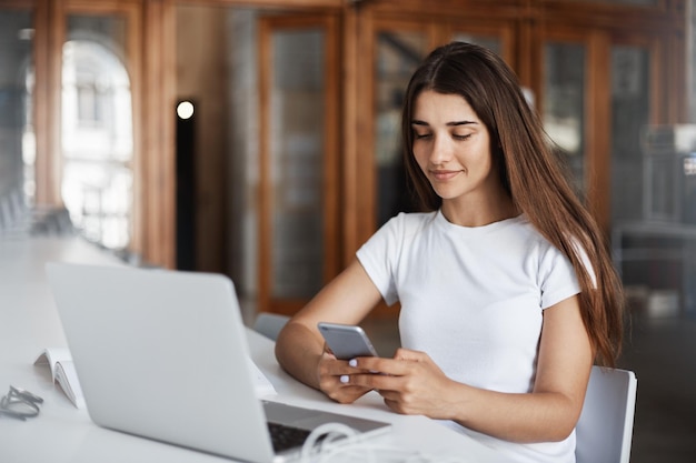 Posh woman using smart phone to text friends and invite them to a party at night Smiling and posting on social media Communications concept