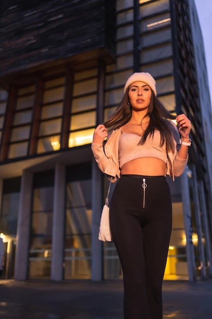 Posing in the city on a winter night wearing a pink knitted sweater and hat