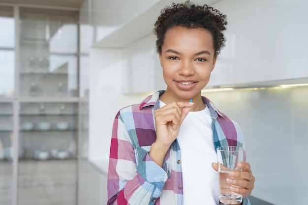 Positive afro girl is taking contraceptive pills Medications and pregnancy prevention concept