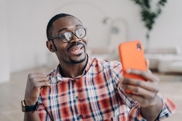 Positive afro man has video call on smartphone Guy stays home and has conversation online