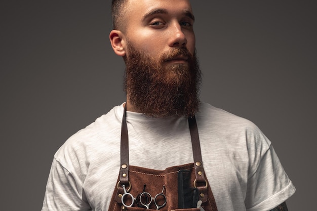 Positive bearded barber looking at camera