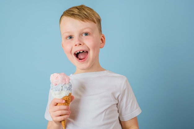 Positive boy holding ice cream on a blue background Health benefits ice cream concept