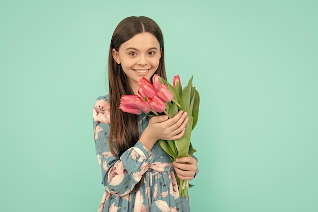 Positive child with tulips mothers or womens day kid hold flowers for 8 of march