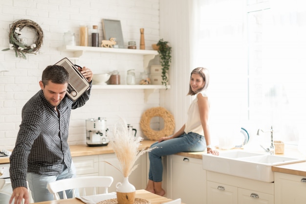 Positive couple having fun at home in the kitchen