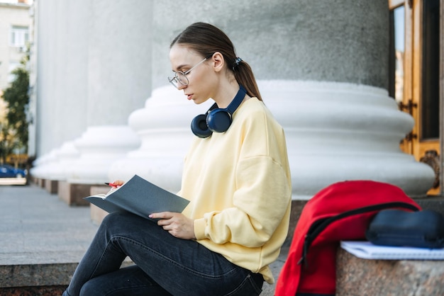 Positive daily affirmations for self love young woman in headphones writing in notebook