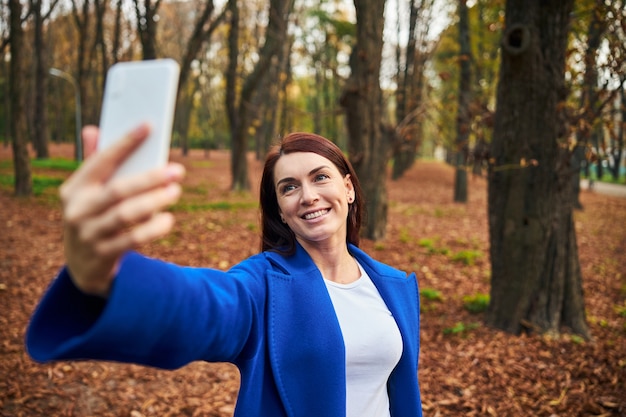 Positive delighted female person taking selfie photo