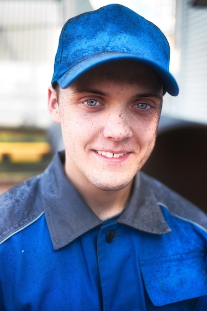 Positive emotions on face of young industrial worker in work clothes and baseball cap Portrait of Caucasian guy