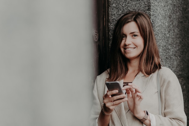 Positive European female with pleasant appearance, reads income message