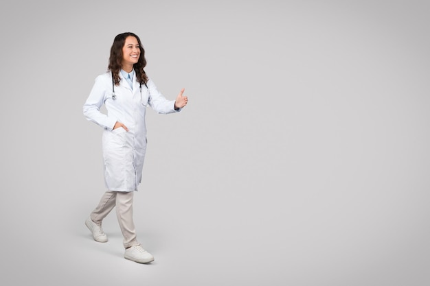 Positive european woman doctor in uniform give hand to patient to handshake on light background free