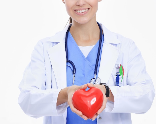 Positive female doctor standing with stethoscope and red heart symbol isolated Woman doctor