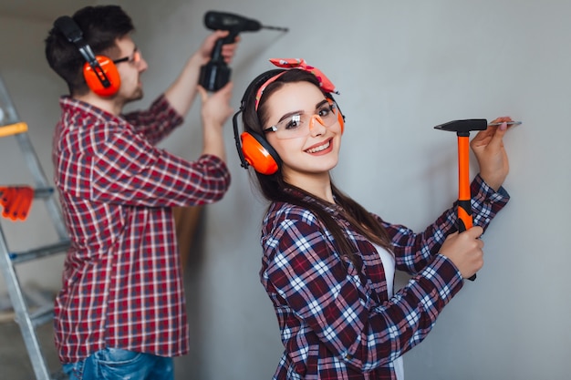 Positive girl clogs the nail with  her boyfriend, wearing at nice equipment