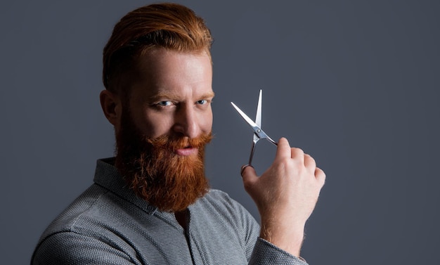 Positive hairdresser man with scissors to make haircut man in hairdresser studio