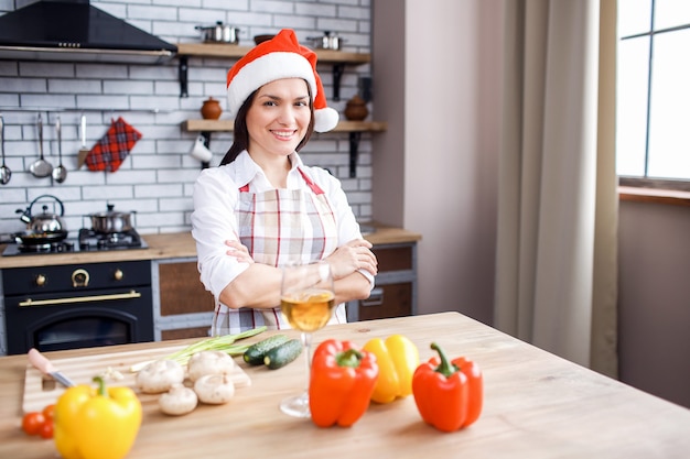 Positive happy adult woman posing on camera in kitchen