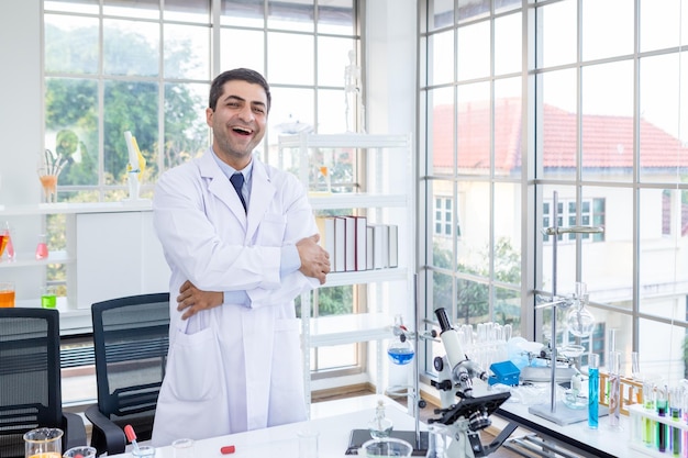 Positive and joyful funny crazy joke emotions Confident scientist portrait of Happy male scientist keeping arms crossed in chemistry lab scientist holding test tube with sample in Laboratory analysis