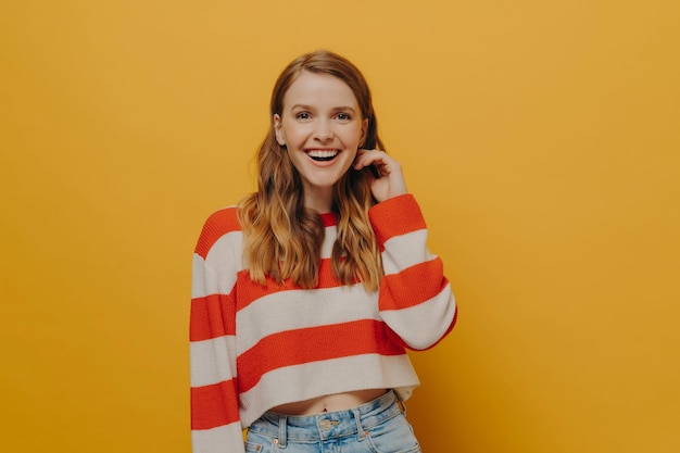 Positive laughing millennial woman in casual clothes smiling after hearing funny joke