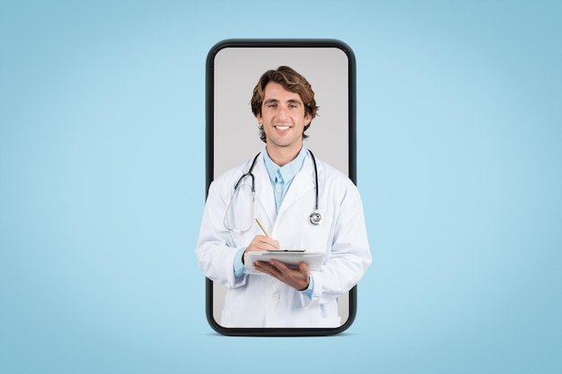 Photo positive male doctor therapist in white coat using tablet on big phone screen isolated on blue