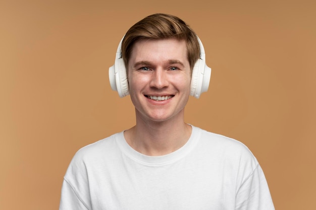 Positive man listening to music wearing headset and rejoicing