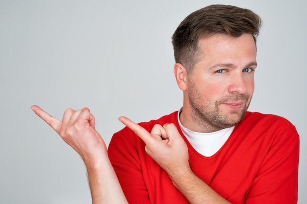 Positive mature caucasian man pointing aside giving advice