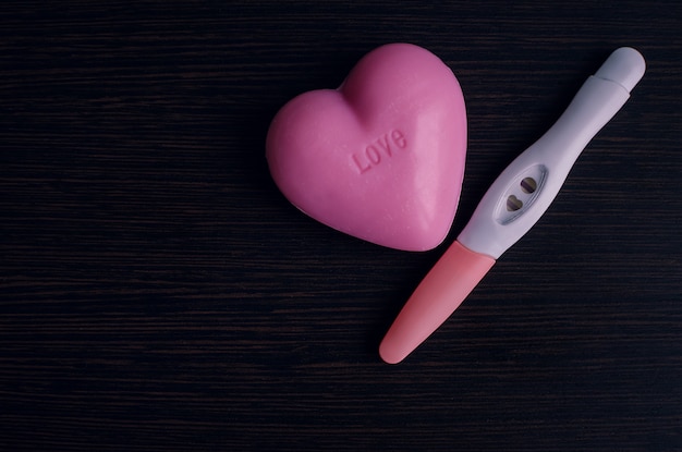 Positive pregnancy test with a pink heart