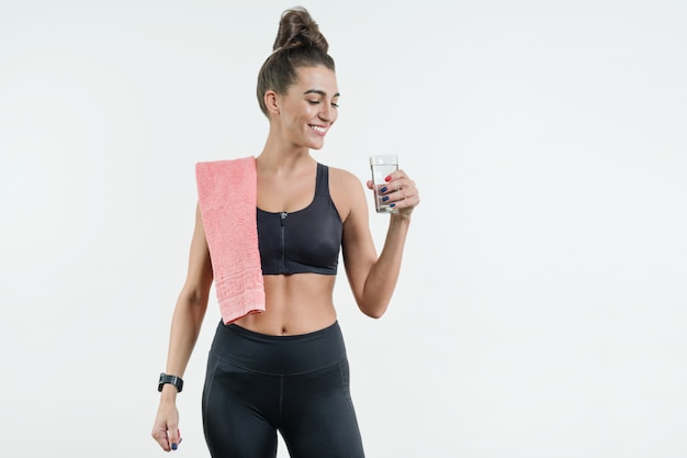 Positive smiling fitness woman drinking water