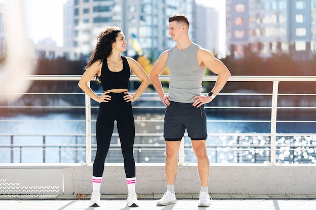 Positive sport couple posing after sport together on the street