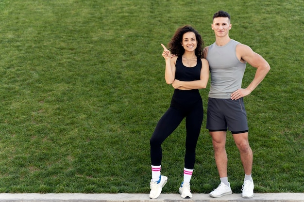 Positive sportive people standing over grass background