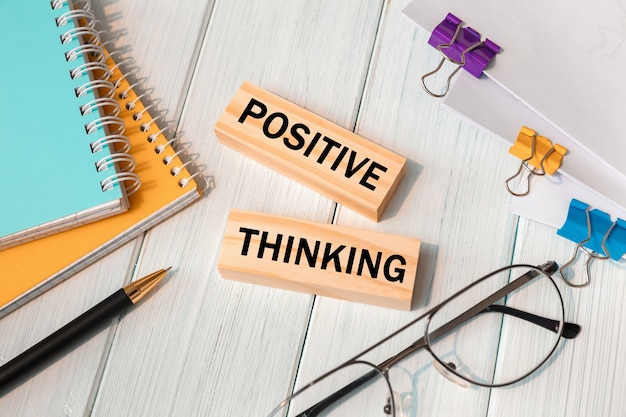 Photo positive thinking  words written on wooden blocks near office supplies