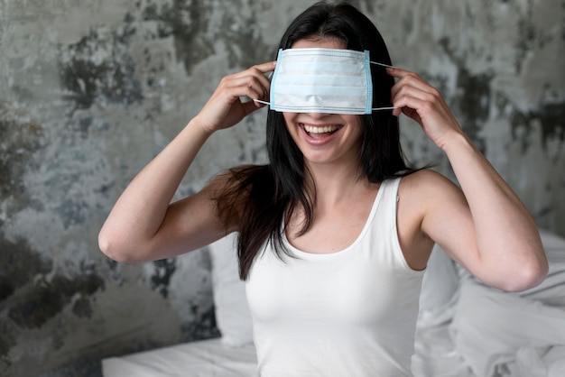 Positive woman playing with face mask