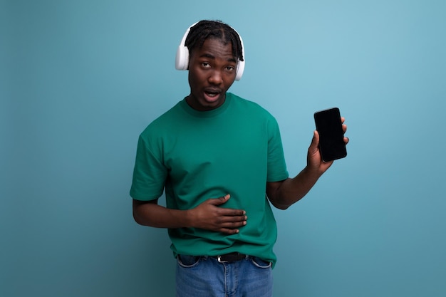 Positive young man listening to music using headphones and smartphone