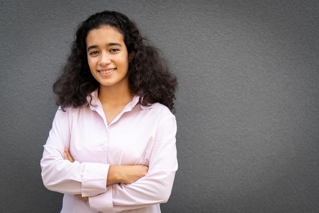 Positive young woman portrait against grey wall