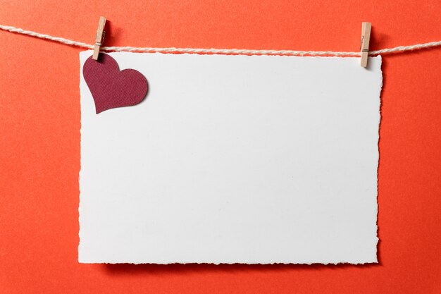 Postcard template with burgundy heart and tiny clothespins on a red background.