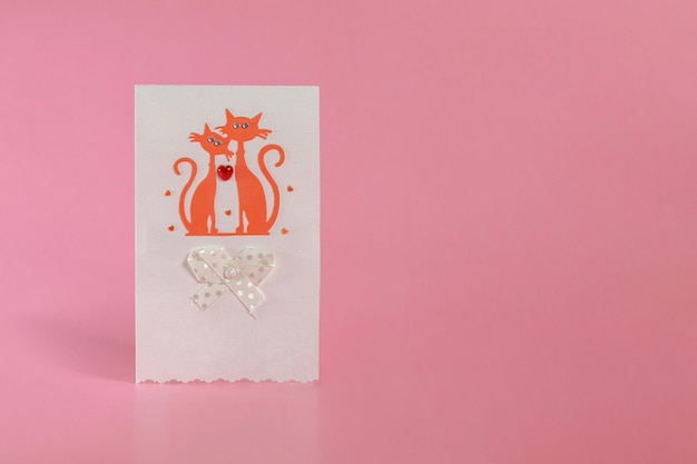 A postcard with cats in love and a heart on a pink background the concept of Valentines Day March