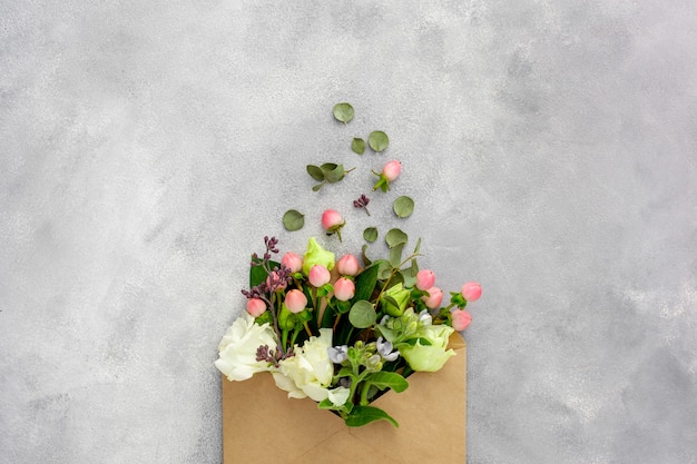 Postcard with open kraft paper envelope filled with spring flowers