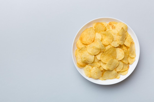 Potato chips on bowl isolated on colored background Delicious crispy potato chips in bowl Space for text Top view