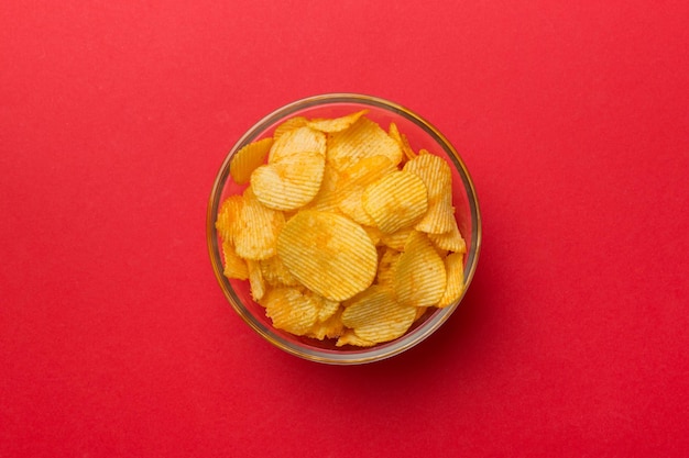 Potato chips on bowl isolated on colored background Delicious crispy potato chips in bowl Space for text Top view