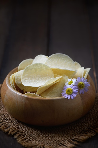 Potato chips bowl on wood background fat food or junk food