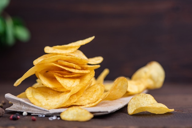 Potato chips in bowl on a wood