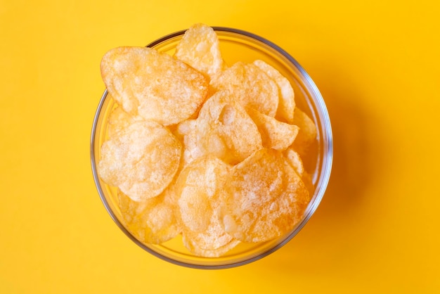 Potato chips in glass bowls on yellow background Junk unhealthy food chips party food fast food