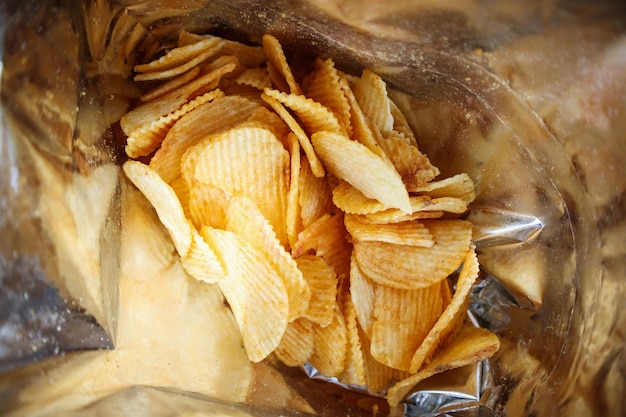 Potato chips in open snack bag close up