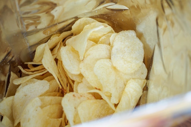 Potato chips in open snack bag close up