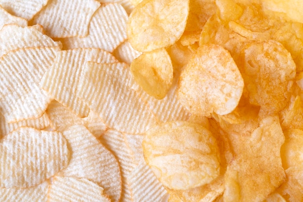 Potato chips texture background top view. Crispy snack, junk food, fastfood, flatlay.