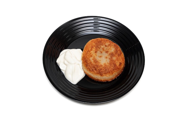 Potato pancakes with sour cream on a plate isolate