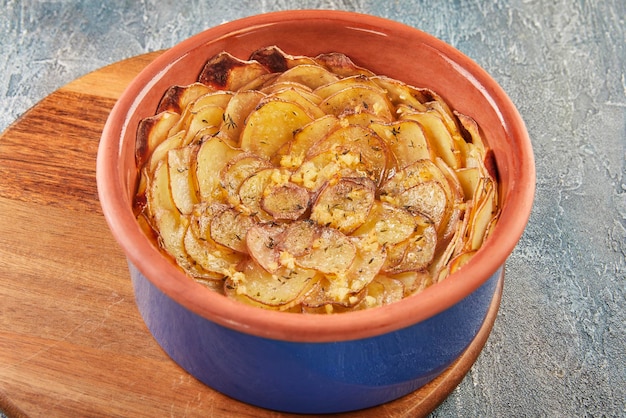 Potato pie with garlic and thyme on wooden board