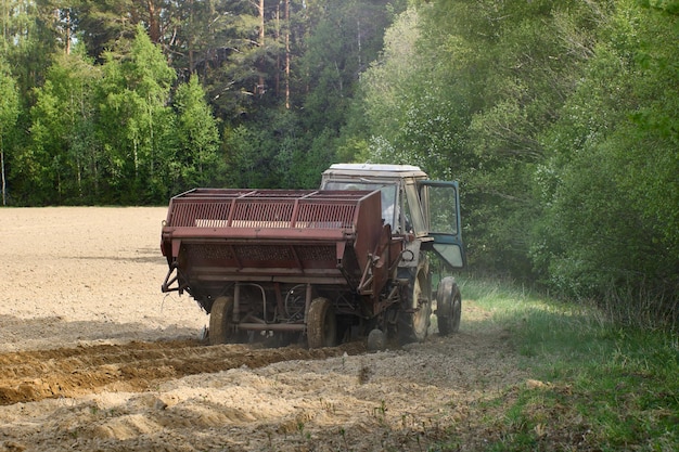 Potato planter is attached to an agricultural tractor for planting potatoes in farmer field