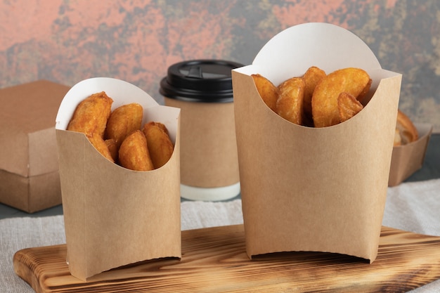 Potato wedges in paper packaging for a delivery