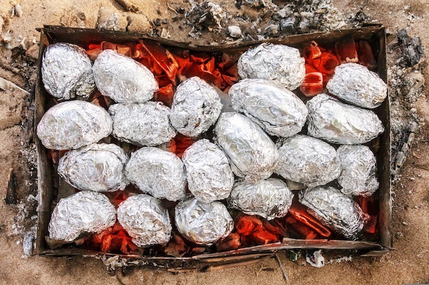 Potatoes baked in foil on the coals