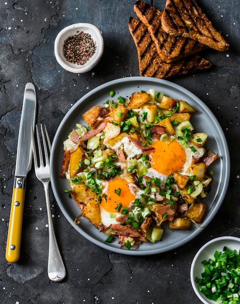 Potatoes ham eggs breakfast hash on a dark background top view Delicious nutritious breakfast snack